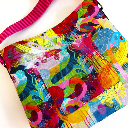 Colorful patterned bag with a pink strap on a white background