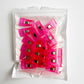 A clear plastic pouch containing a 20-pack of bright pink translucent sewing clips designed for securing fabric layers during sewing and crafting projects.