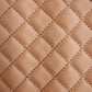 a detailed close-up of beige-colored vinyl with a quilted diamond stitch pattern, highlighting the texture and thread detail of the stitching.