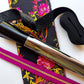 Black floral fabric with pink flowers, black webbing, pink zipper and metallic bag hardware from Sew Hungry Hippie