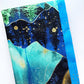 Blue and turquoise abstract fabric bundle with forest silhouettes, wave-like shapes, and shimmering gold metallic accents.