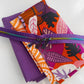  A detailed view of a SewHungryHippie bundle showing folded purple bonded nylon and patterned fabric secured with a purple zipper featuring three pulls.