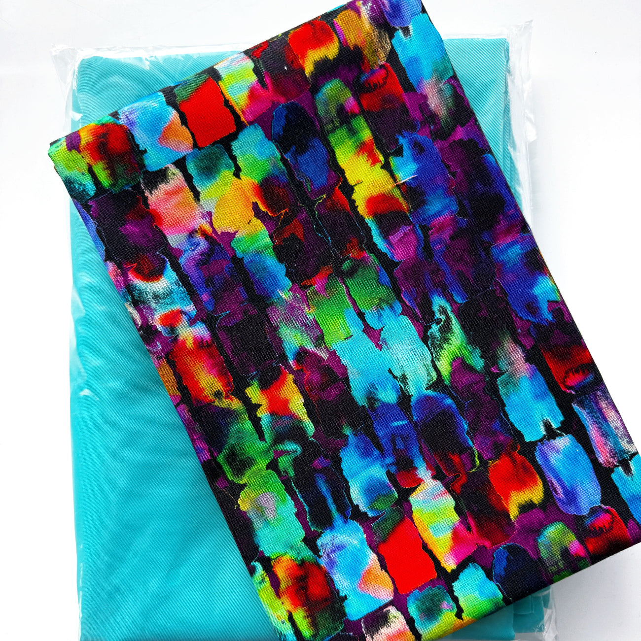 Colorful abstract brushstroke fabric in vibrant blue, purple, pink, green and red paired with turquoise fabric from Sew Hungry Hippie