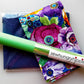 Sew Hungry Hippie colorful floral fabric bundle with navy sewing fabric and green sewing tool.