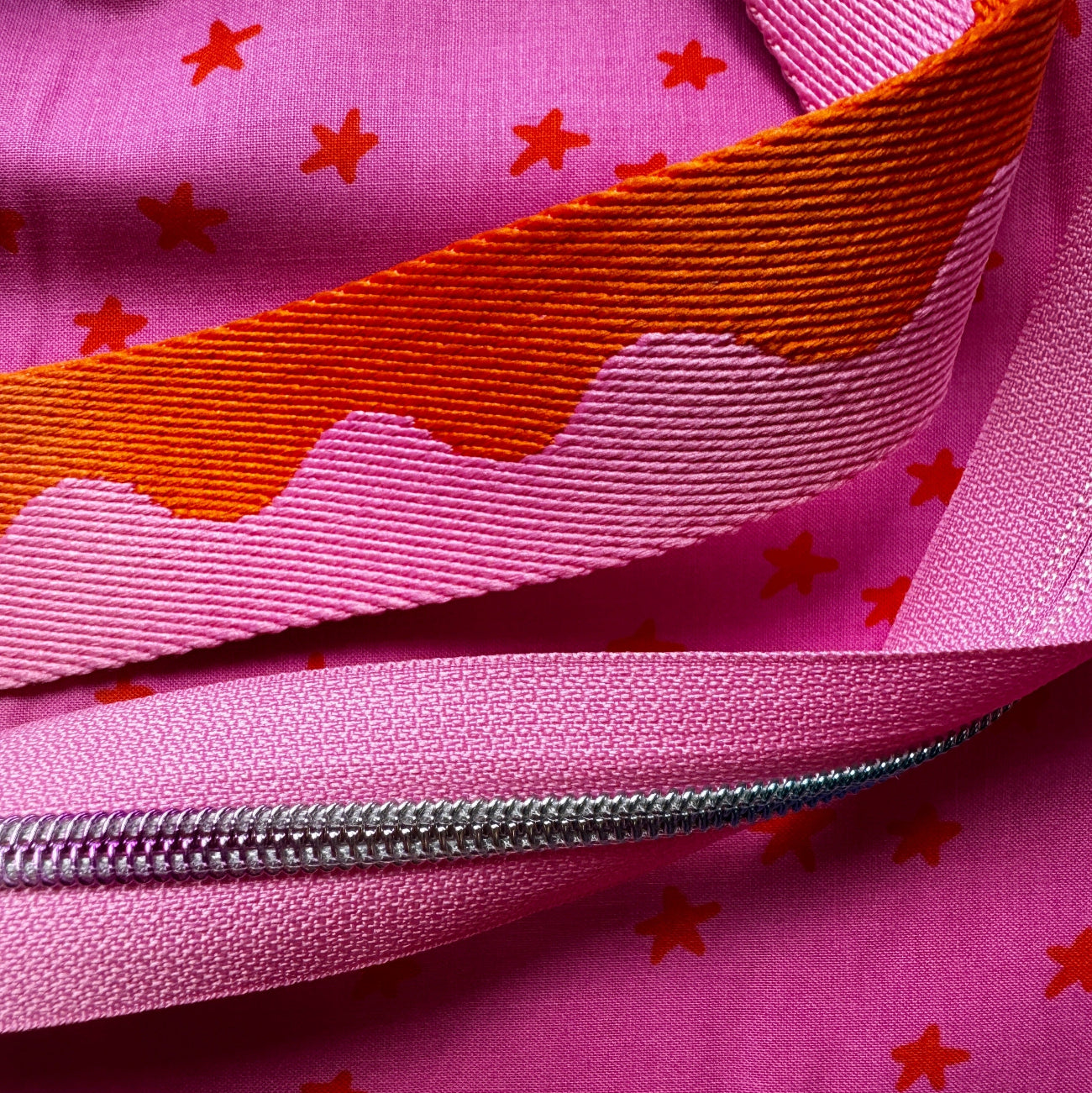 Pink star print fabric with pink webbing and silver zipper tape from Sew Hungry Hippie