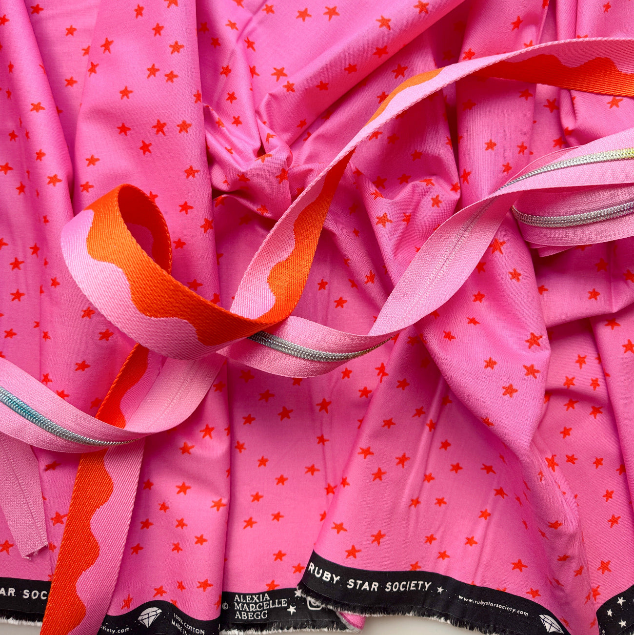 Pink star print fabric bundle with pink and orange webbing and silver zipper tape from Sew Hungry Hippie