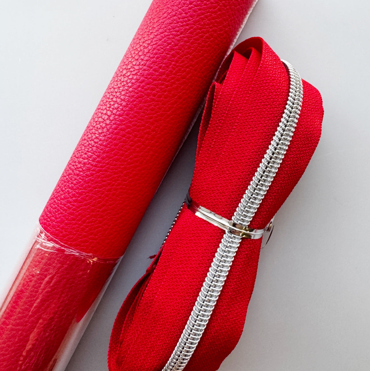 Red textured vinyl paired with red zipper tape and silver zipper teeth from Sew Hungry Hippie