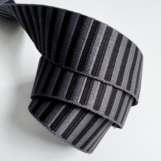 A 1.5-inch wide jacquard woven webbing strap featuring a charcoal grey and black horizontal stripe pattern, neatly coiled against a white background.