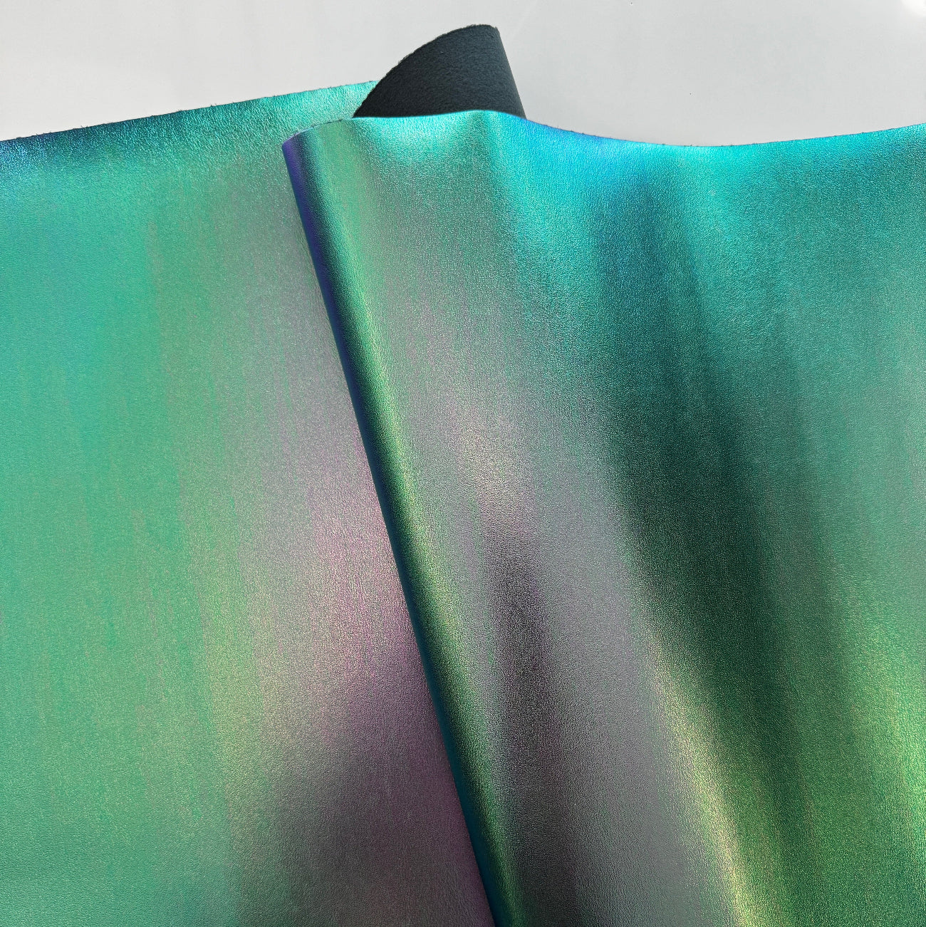 High-quality iridescent green synthetic leather material with a smooth, reflective surface for bag making projects