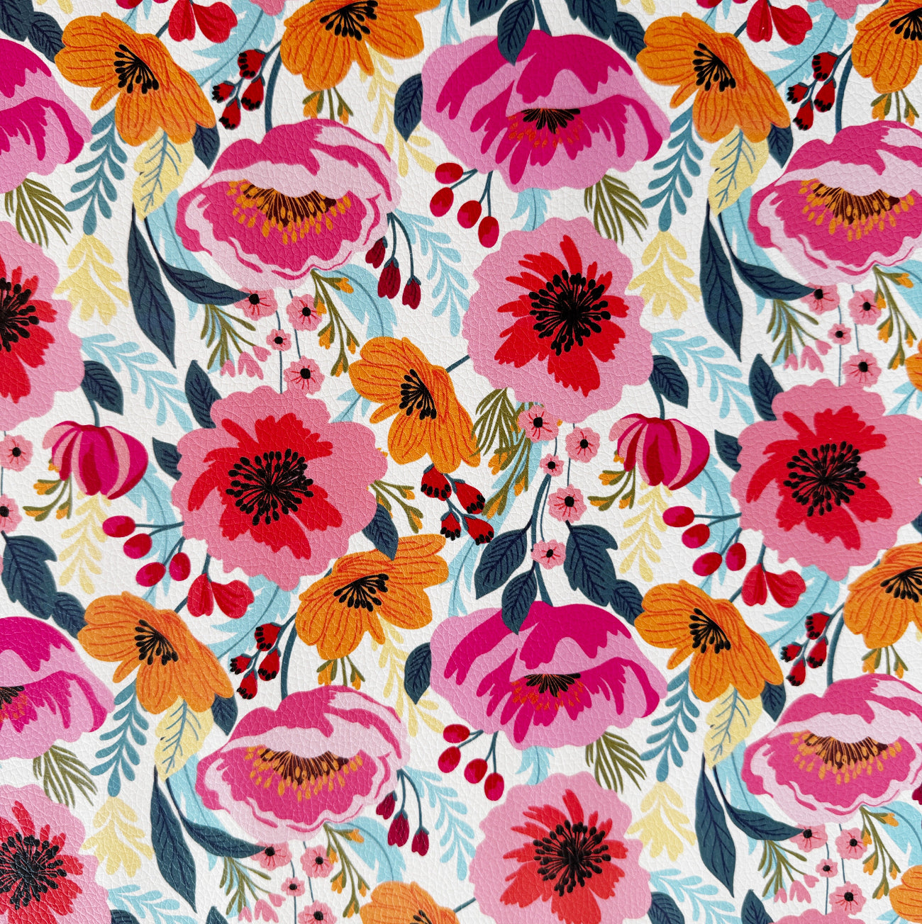 Closed up image of bright floral print vinyl fabric with bold poppy flowers in pink and orange tones designed for sewing, bag making, and crafting