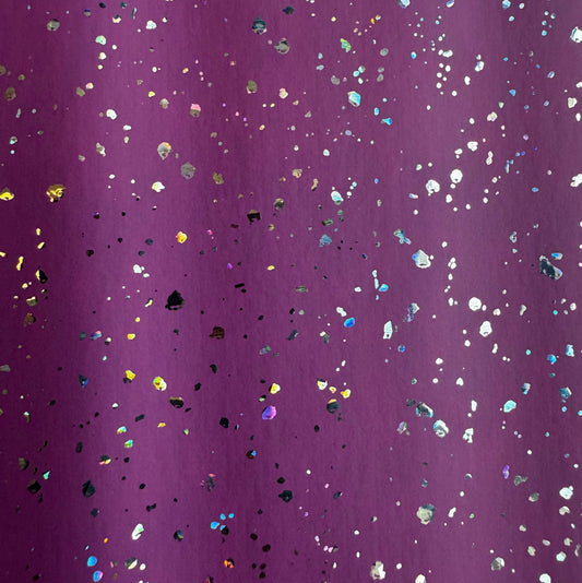 Purple glitter fabric with scattered iridescent holographic confetti dots.