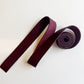 Maroonbag strap with a roll on a white background
