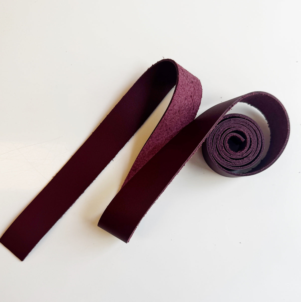Maroonbag strap with a roll on a white background