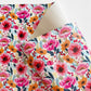 Closed up image of Poppy Punch floral vinyl fabric featuring vibrant pink, orange, and red flowers with detailed botanical pattern on a white background