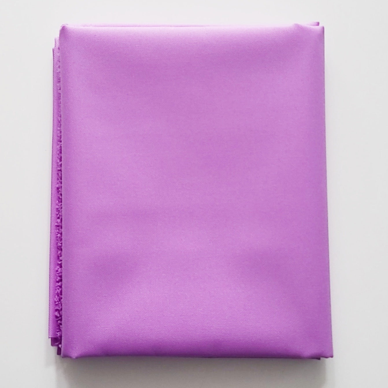 Folded purple fabric on a light gray background