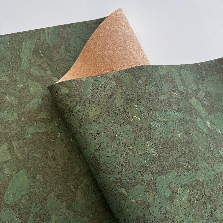 Green textured cork with a brown corner on a white background