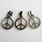 Three metallic silver-tone zipper pulls featuring a classic circular peace sign charm, aligned side-by-side against a plain white background.