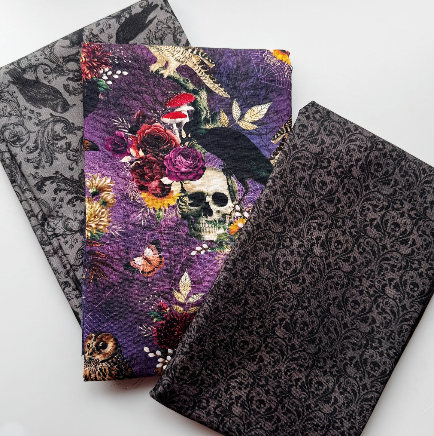 Spooky Halloween fabric bundle with skulls, ravens, flowers, mushrooms, owls, and dark patterns for sewing and bag making.