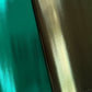 Close-up of two glossy metallic synthetic fabric sheets side by side, featuring smooth teal-green metallic vinyl on the left and textured bronze olive-gold iridescent vinyl on the right with a reflective finish that shifts from deep brown to golden green. Eye-catching metallic materials for handmade handbags, purses, wallets, accessories, and DIY bag-making projects.