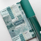 Teal travel ticket print fabric paired with textured teal faux leather for a handmade bag project.