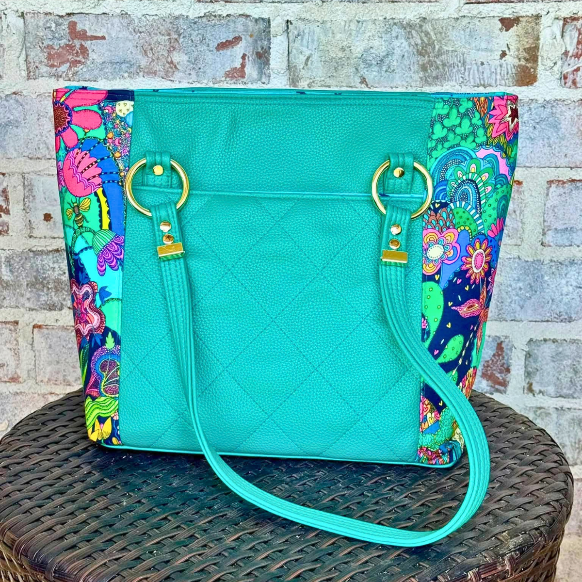 Back of teal quilted Moonglow vinyl tote with colorful floral side panels