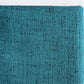 A close-up of a textured fabric or material swatch in a teal blue-green color with subtle darker flecks, shown against a plain white background.