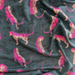 A close-up view of Rayon fabric featuring a dark teal background with a repeating pattern of stylized tigers in vibrant shades of pink and orange, accompanied by small black wavy lines.