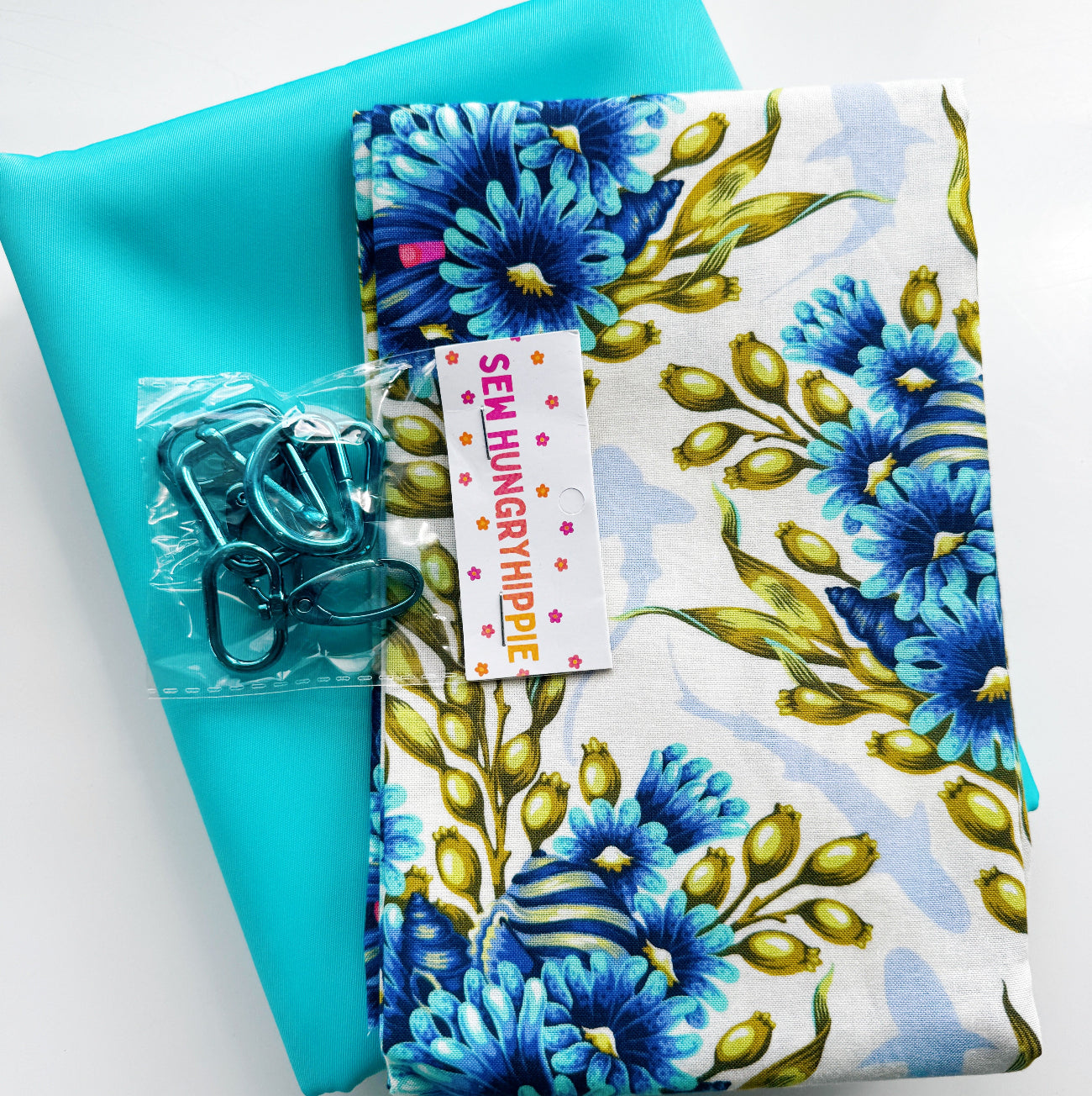 Turquoise faux leather paired with coordinating blue floral cotton fabric and teal bag hardware, perfect for handbags, totes, backpacks, wallets, crossbody bags, and sewing projects.