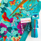 Turquoise floral and butterfly fabric with matching teal zipper, silver bag hardware, and sewing accessories for DIY bag making