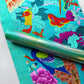 Turquoise peacock and floral fabric paired with metallic green textured vinyl for sewing and bag making.