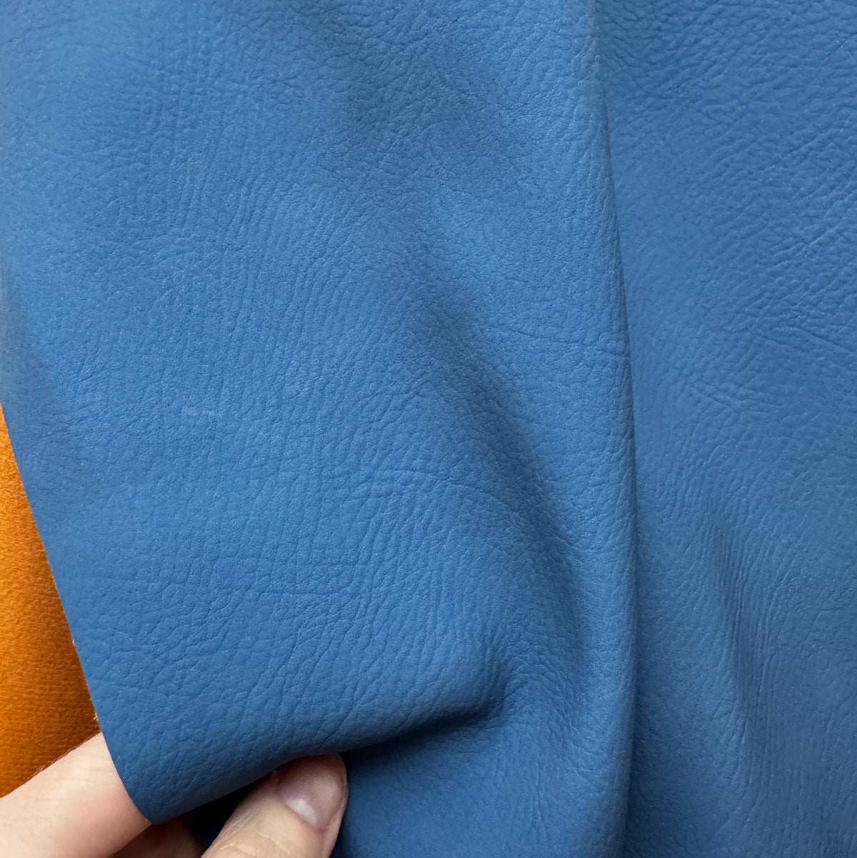  Blue pebbled-grain faux leather vinyl fabric featuring a textured leather-like surface, ideal for bag making, upholstery, crafts, and DIY sewing projects.