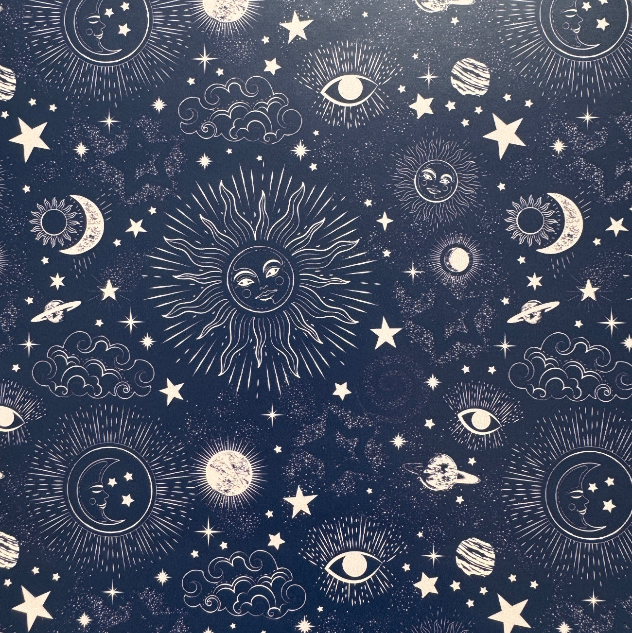  celestial pattern with sun, moon, stars, and planets on a dark blue background