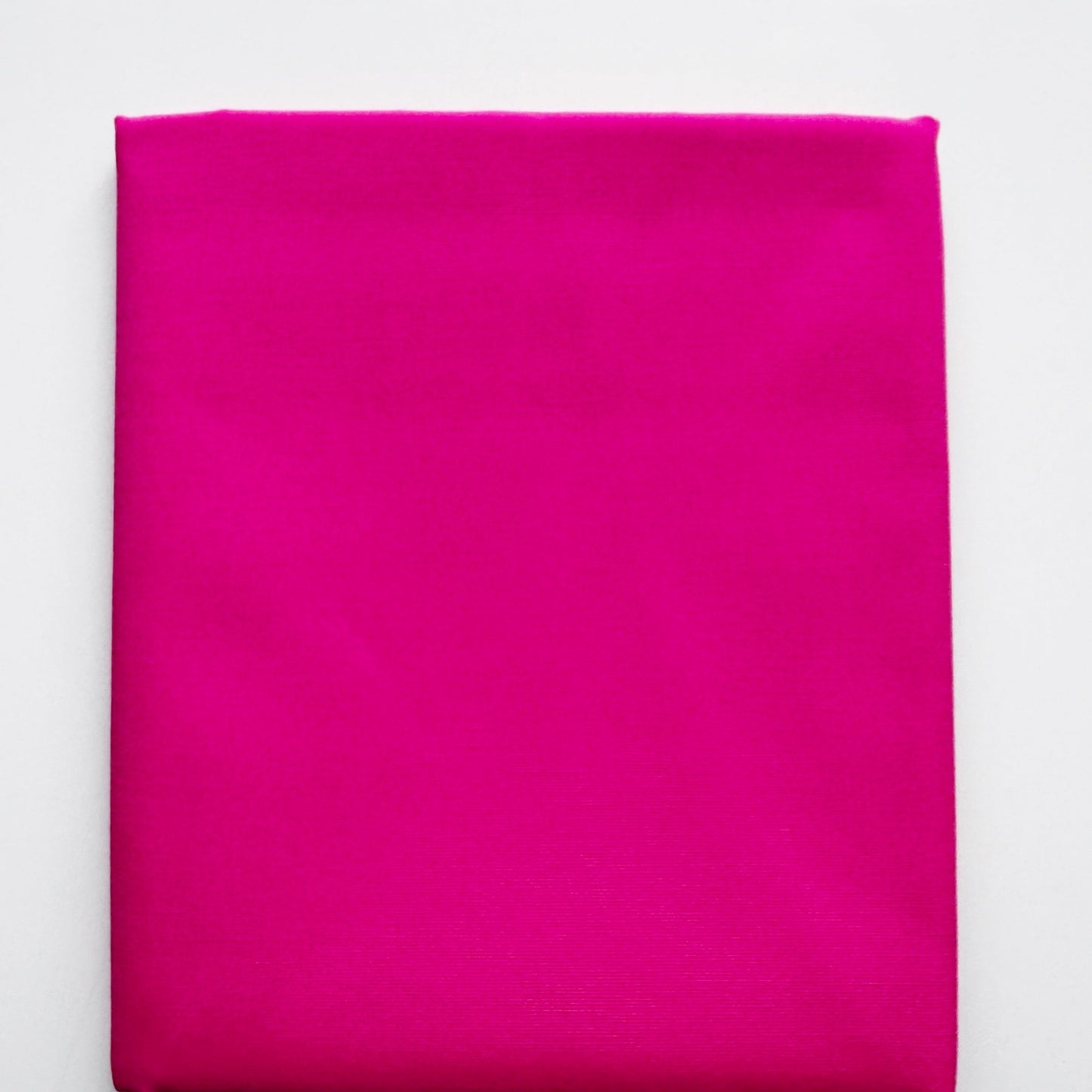 Folded bright pink fabric on a white background