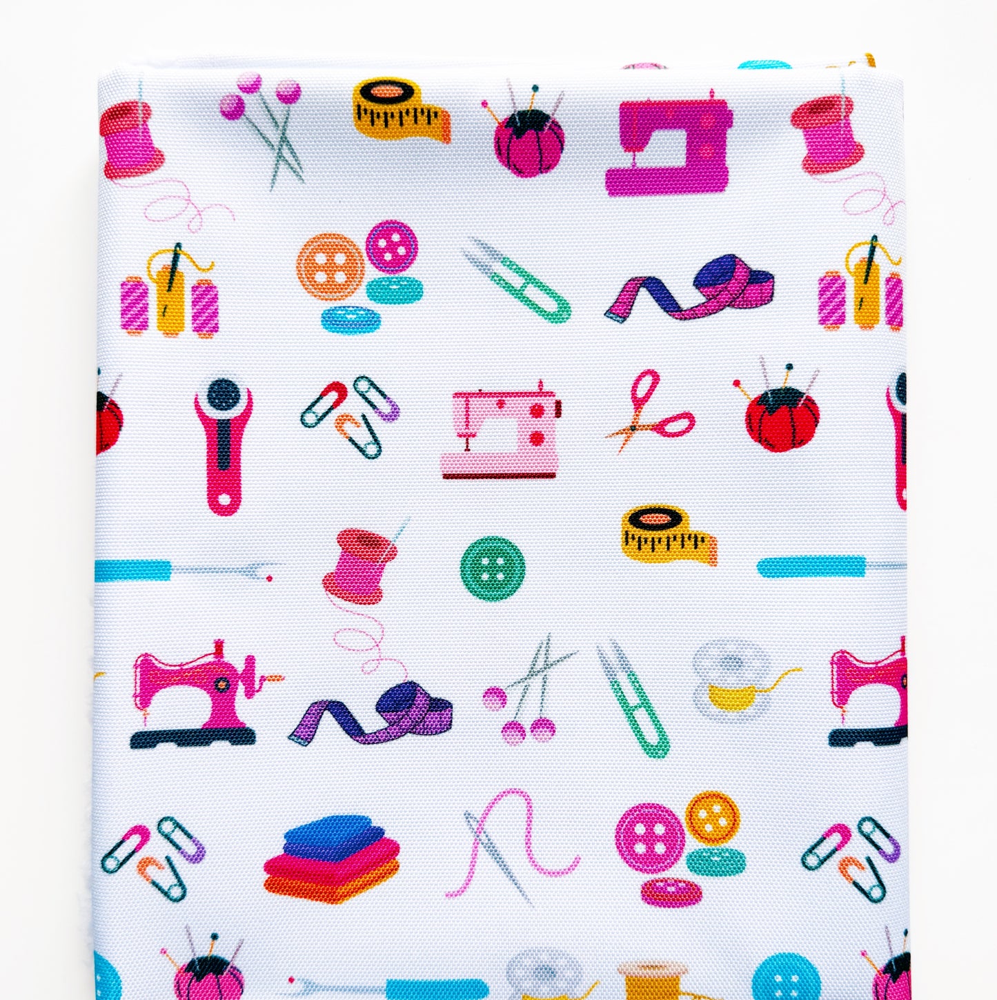 Patterned fabric with colorful sewing-related icons on a white background