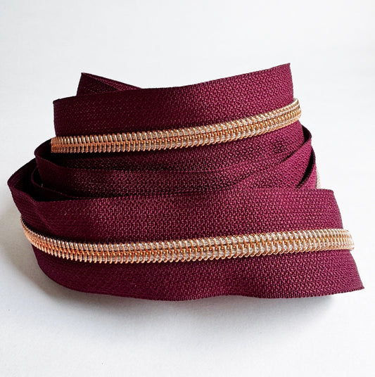 3-yard cut of #5 wine red continuous nylon zipper tape with rose gold teeth for handbags, purses, wallets, pouches, and bag making sewing projects.