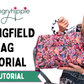 A woman wearing glasses and a patterned top holds up a colorful floral Springfield bag, with large text reading 'SEWHUNGRHYIPPIE SPRINGFIELD BAG TUTORIAL VIDEO TUTORIAL' on a white background.
