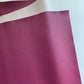Berry magenta-purple pebbled faux leather vinyl fabric with lychee grain and cream woven backing