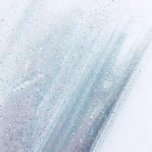 The image shows a transparent Clear Glitter Vinyl sheet embedded with fine, silver sparkle flakes.