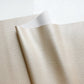 Cose-up of Champagne Moonglow vinyl faux leather fabric, showing its finely pebbled grain texture and subtle metallic sheen.