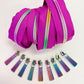 Fuchsia continuous zipper tape with coordinating iridescent rainbow zipper pulls displayed for bag making, purse sewing, and DIY sewing projects.