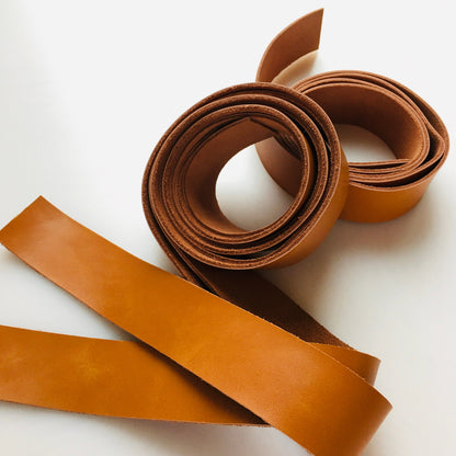 Brown leather strips coiled and laid out.