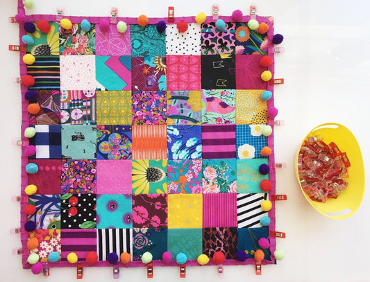 colorful fabric squares with pom-pom trim