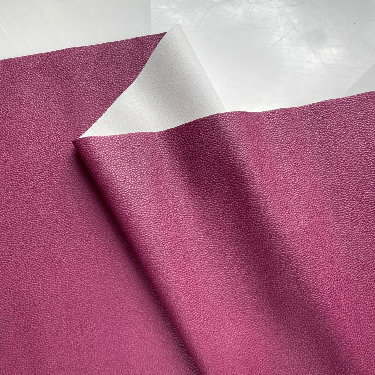 Pomegranate magenta pebbled faux leather vinyl fabric with smooth white knit backing