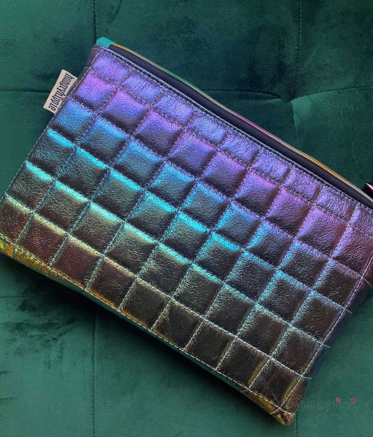 Iridescent quilted clutch on green velvet.